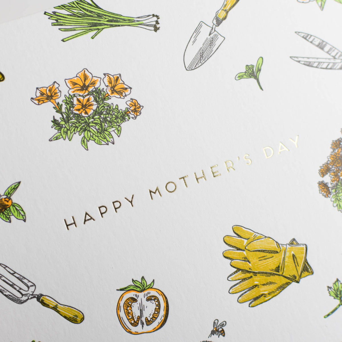 Close-up of Mother's Day gardening card with watering can, rake, and “Happy Mother's Day”