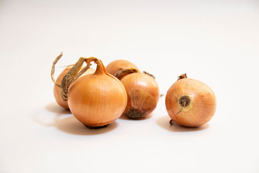 Whole yellow onions with golden skin on a white background
